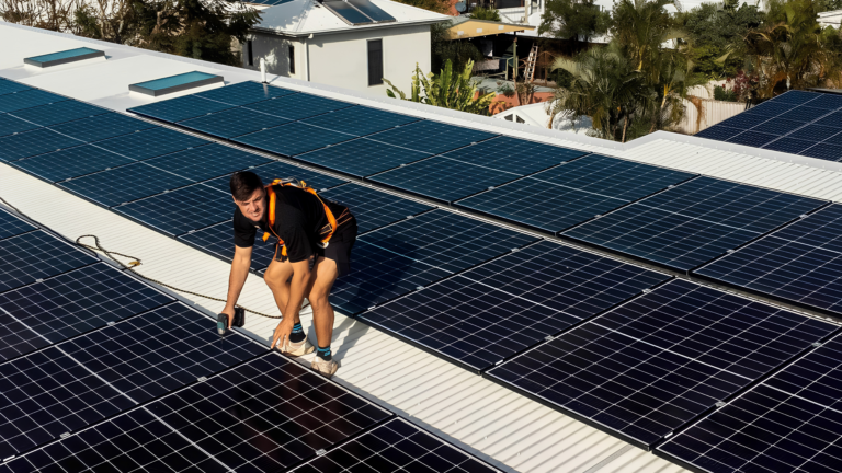 Workers installing solar panels on a rooftop.